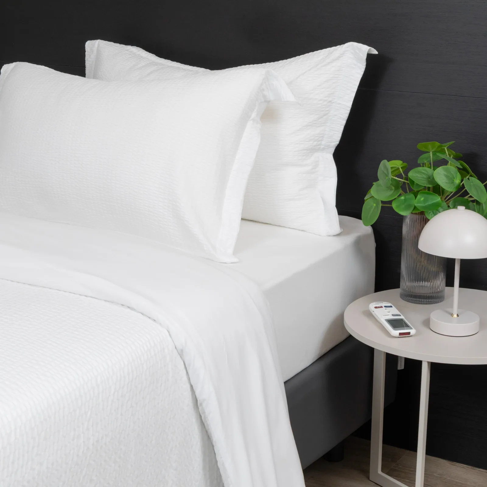 Letto con biancheria bianca e comodino in un appartamento B&B
