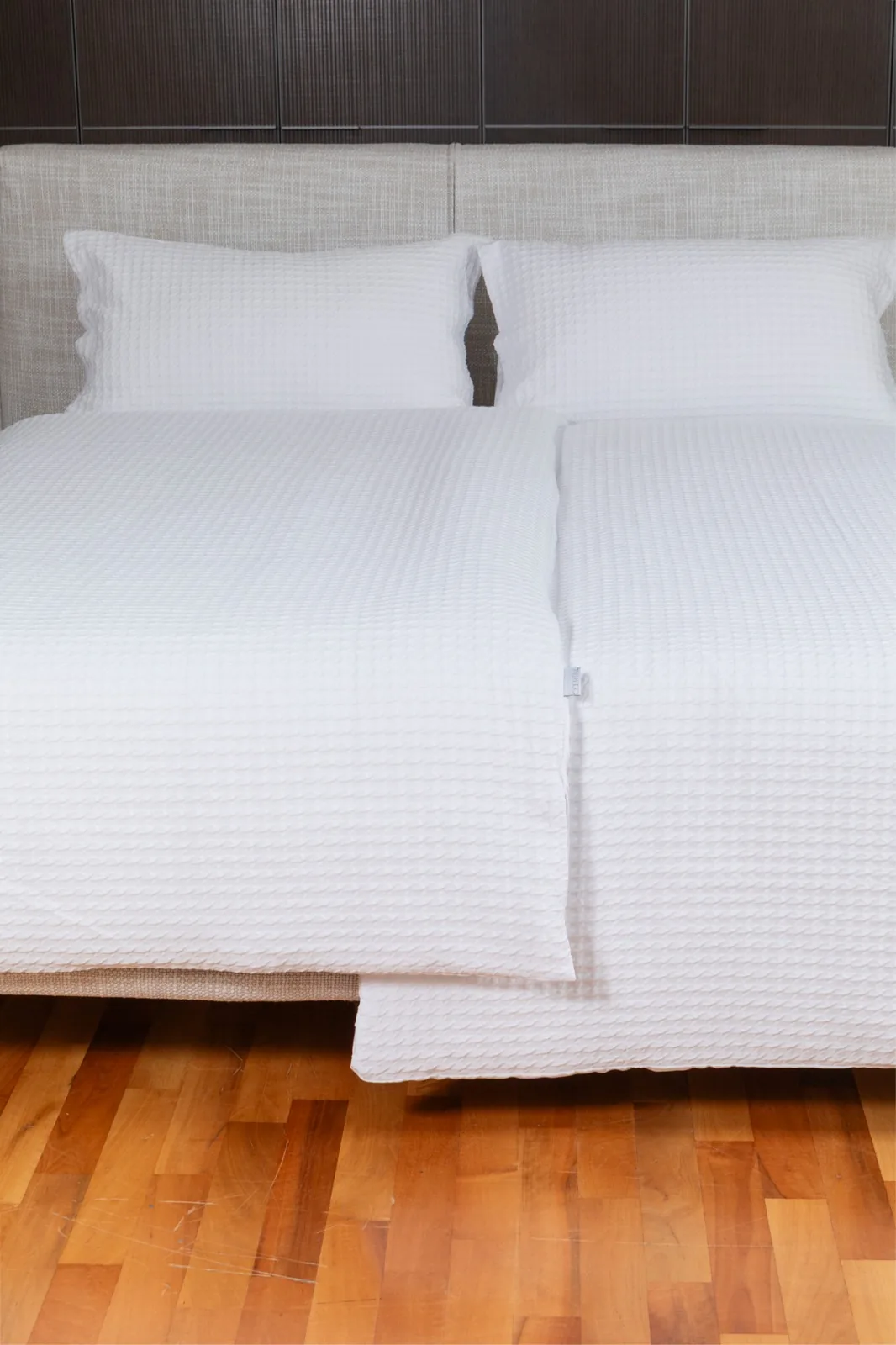 Letto d'albergo con biancheria bianca in piquet